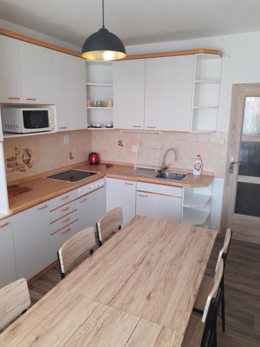 Il comprend une cuisine avec une table et des chaises en bois. dans l'établissement Apartmán u Lidušky, à Břeclav