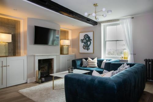 a living room with a blue couch and a fireplace at The Bakery by The Butler Collection in Arundel