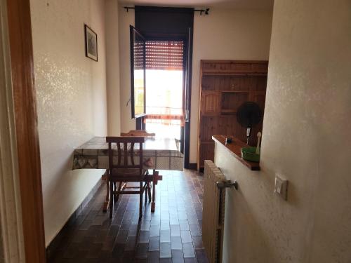 une cuisine avec une table et des chaises ainsi qu'une fenêtre dans l'établissement Casa di Adele, à Anzio