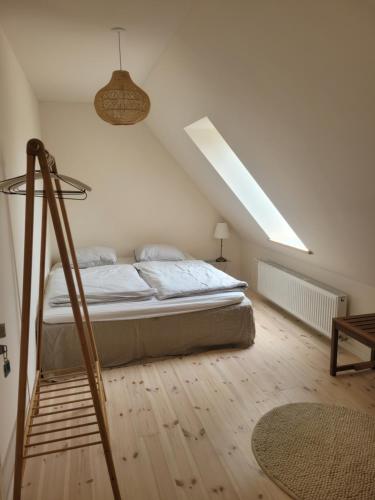 een witte slaapkamer met een bed en een dakraam bij Atma Guesthouse - cozy and simple bed & breakfast in the countryside in Marstal