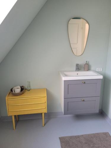 a bathroom with a sink and a mirror at Atma Guesthouse - cozy and simple bed & breakfast in the countryside in Marstal