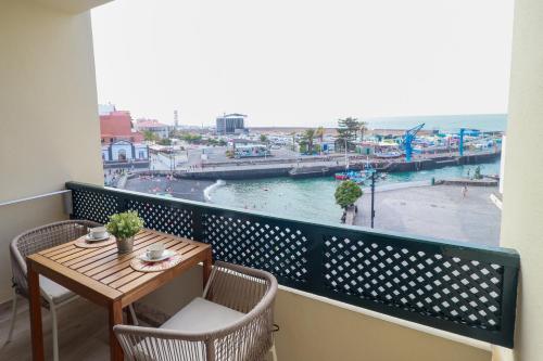 a balcony with a table and chairs and a view of a harbor at SUN-SEA in Puerto de la Cruz