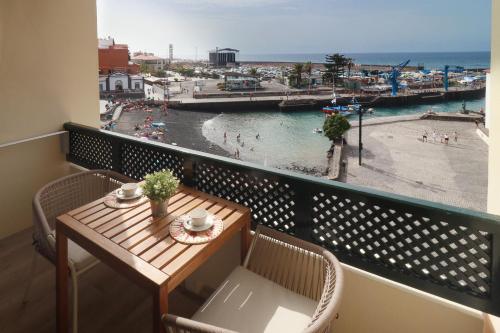 a balcony with a table and chairs and a view of a beach at SUN-SEA in Puerto de la Cruz