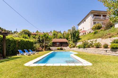 a swimming pool in a yard with chairs and a house at Chalé da Caniçada By Sé Apartamentos in Rio Caldo