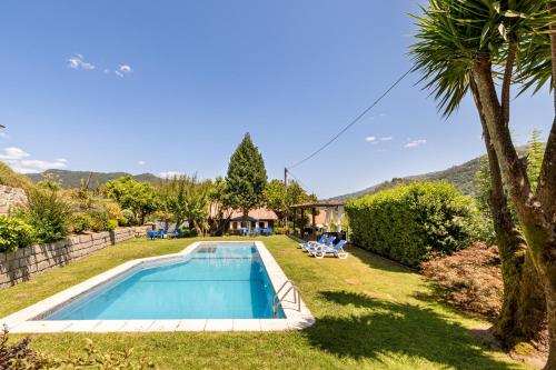 an image of a swimming pool in the yard of a house at Chalé da Caniçada By Sé Apartamentos in Rio Caldo