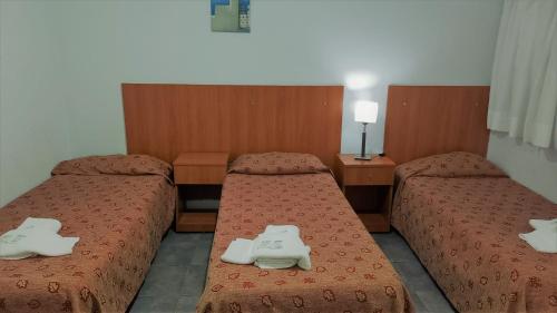 a room with two beds with white shoes on them at Hotel Caribe in Mar del Plata