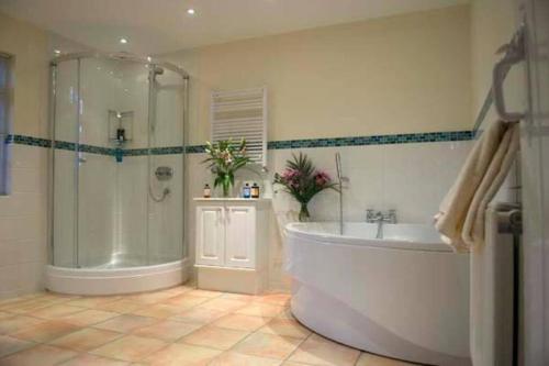 a large bathroom with a tub and a shower at The Highlands - Nr Rye - Tennis Court in Iden