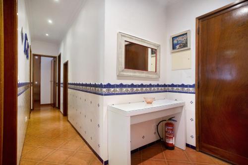 uma casa de banho com um lavatório branco e um espelho. em Akademia House - Cantinho da Nazaré na Nazaré