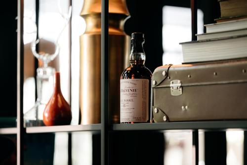 a bottle of wine sitting on a shelf with a suitcase at Boutiquehotel 't Fraeyhuis - adults only in Bruges