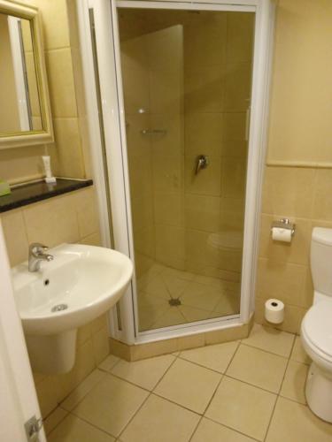a bathroom with a shower and a sink and a toilet at Protea Hotel by Marriott Bloemfontein in Bloemfontein