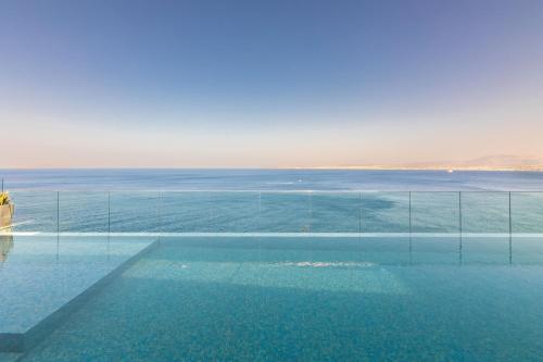a swimming pool with a view of the ocean at Rocca al Mare Seaside Villas in Palaiokastro
