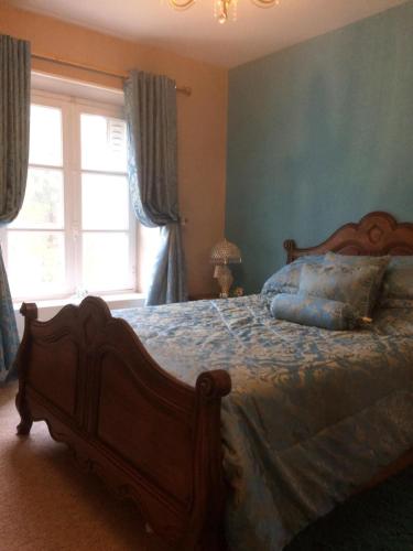 une chambre avec un lit aux murs bleus et une fenêtre dans l'établissement Stylish House near Lake and Beach at St Estephe, à Augignac