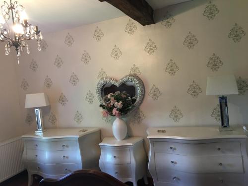 Cette chambre dispose de deux commodes et d'un miroir au mur. dans l'établissement Stylish House near Lake and Beach at St Estephe, à Augignac