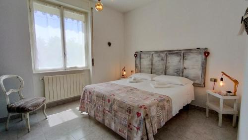 a bedroom with a bed and a chair and a window at Sweetheart Apartment in Busto Arsizio