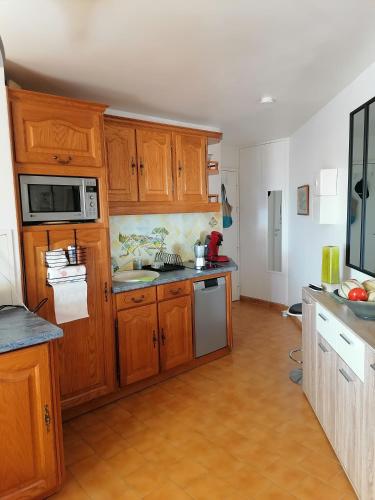 une cuisine avec des armoires en bois et un comptoir dans l'établissement Balcon sur la Méditerranée St Aygulf centre, 4 couchages, à Fréjus