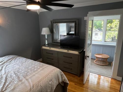 a bedroom with a bed and a television on a dresser at Spacious 5 Bed 2 Bath near Syracuse University and Downtown Syracuse With Lots of Amenities and Free Parking in Syracuse