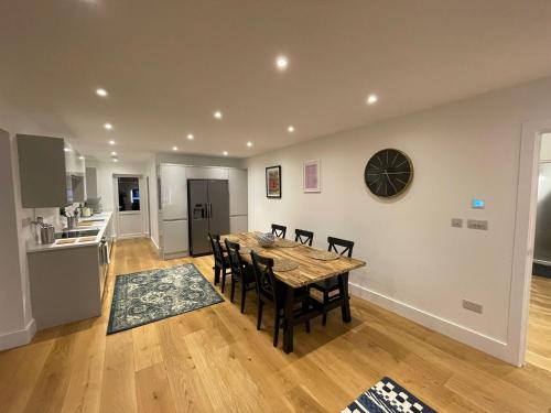 a kitchen and dining room with a table and chairs at Addlestone Exquisite 6 double bedrooms and 3 Bathroom Detatched House 9 in Addlestone