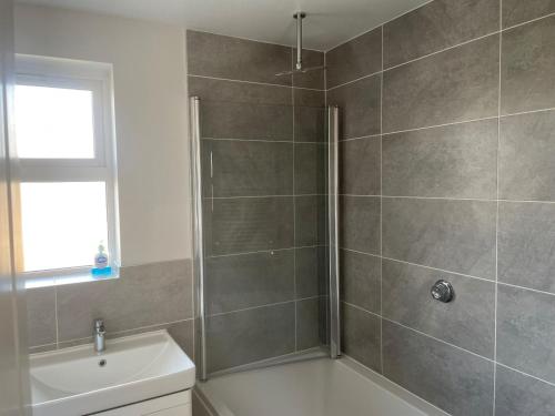 a bathroom with a shower and a toilet and a sink at Gorgeous 3 Bedroom 2 Bathroom Family Home in Bracknell