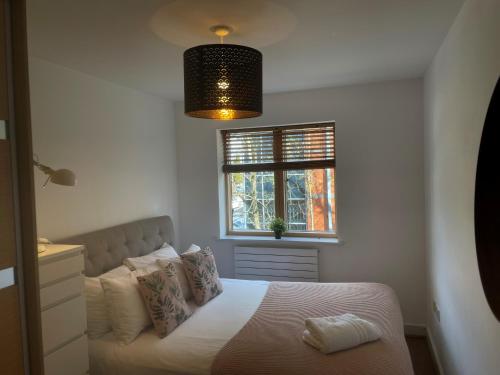 MAIDENHEAD Stylish and modern 2 bedroom apartment في ميدينهيد: غرفة نوم بسرير ونافذة