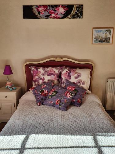 a bedroom with a bed with pillows on it at Le Presbytère Bed & Breakfast in Saint-Romain