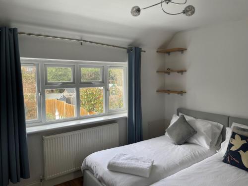 a bedroom with two beds next to a window at Sunningdale Stunning Spacious 4 Bedroom House 11 in Sunningdale