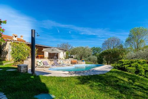 - une piscine dans une cour avec des chaises et une maison dans l'établissement Villa DiVino by IstriaLux, à Bičići