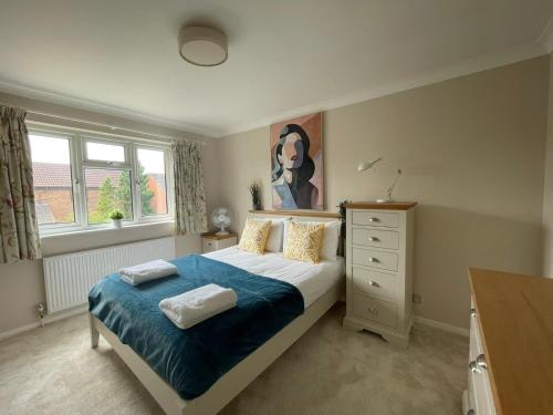 um quarto com uma cama e um quadro na parede em Addlestone Stylish Modern 3 bedroom house 6 em Addlestone