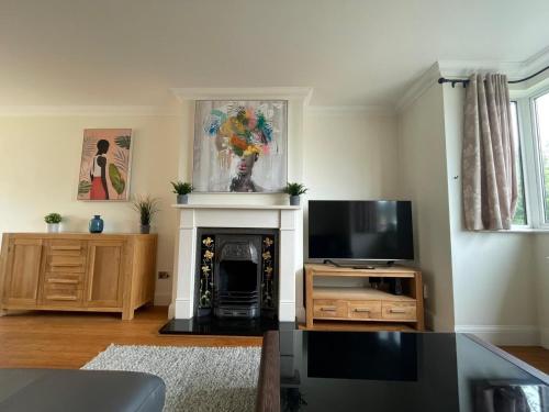 uma sala de estar com lareira e televisão em Addlestone Stylish Modern 3 bedroom house 6 em Addlestone