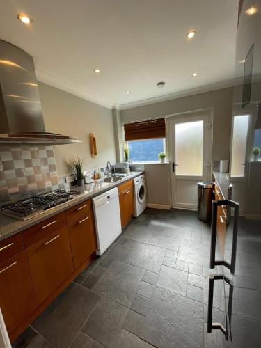 a kitchen with a sink and a stove top oven at Addlestone Stylish Modern 3 bedroom house 6 in Addlestone