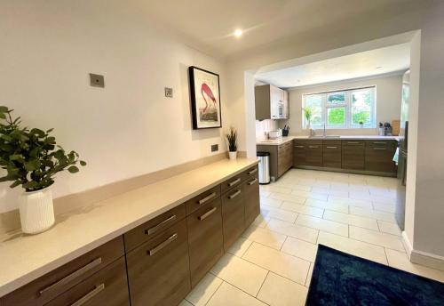 a large kitchen with a counter and a sink at Chertsey Luxurious Three Bedroom Two Bath Home 3 in Chertsey
