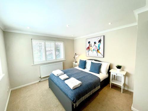 1 dormitorio con 1 cama extragrande con sábanas azules en Chertsey Luxurious Three Bedroom Two Bath Home 3, en Chertsey
