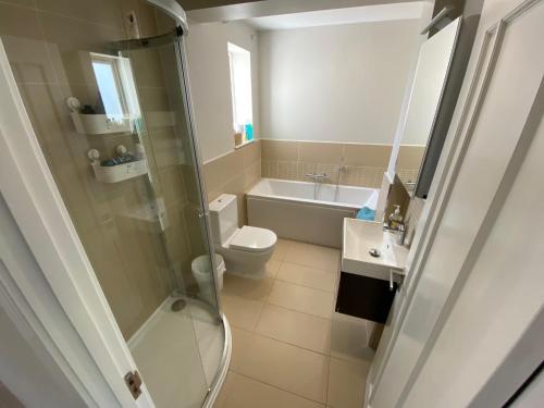 a bathroom with a shower and a toilet and a sink at Ascot stunning and modern 4 bedroom town house with 156 sq ft garden office 28 in Ascot
