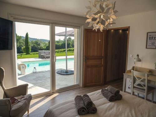 une chambre avec un lit et une vue sur une piscine dans l'établissement Villa Maurine - Piscine chauffée - Spa - Clim - Salle de Fitness, à Castelnau-de-Montmiral