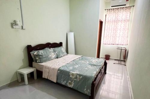 Schlafzimmer mit einem Bett und einem Fenster in der Unterkunft Kayak D'bali Homestay in Pasir Puteh