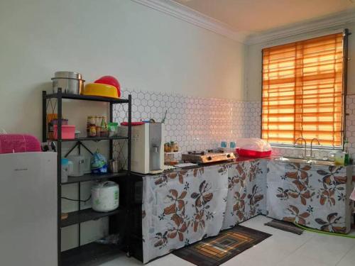 uma cozinha com bancada num quarto em Kayak D'bali Homestay em Pasir Puteh