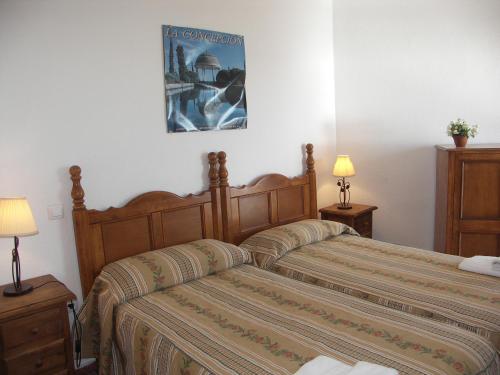 a bedroom with a bed and two night stands and two lamps at Apartamentos Lual Torrecilla in Nerja