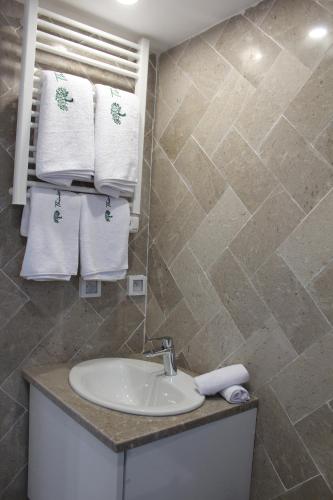 a bathroom with a sink and towels on a wall at Villa a la montagne Hammamet in Hammamet