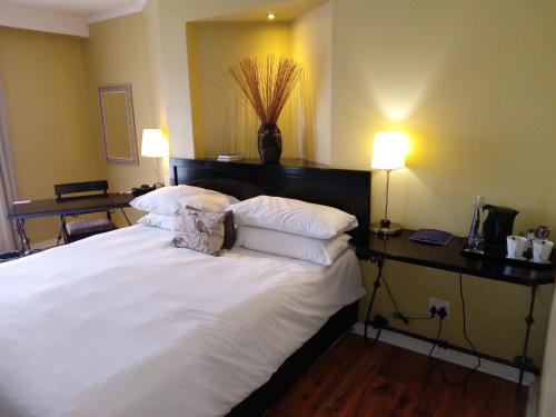 a bedroom with a large bed with white sheets and pillows at Protea Hotel by Marriott Bloemfontein in Bloemfontein