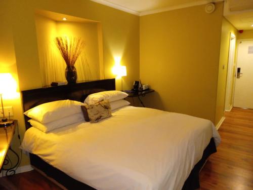a bedroom with a large white bed with two pillows at Protea Hotel by Marriott Bloemfontein in Bloemfontein