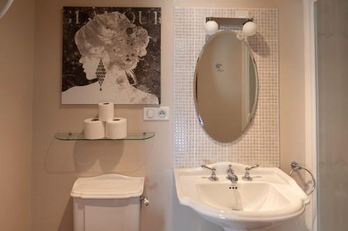 een badkamer met een wastafel, een spiegel en een toilet bij Moulin du Fontcourt in Chasseneuil-sur-Bonnieure