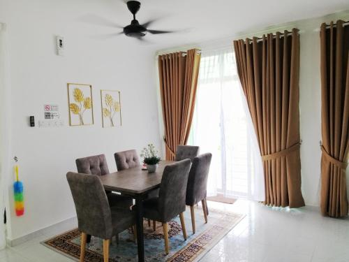 a dining room with a wooden table and chairs at YY Homestay Pasir Mas in Pasir Mas