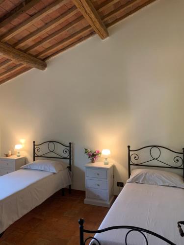 a bedroom with two beds and two night stands with lamps at Casa Vacanze Al Fontanile in Santa Fiora