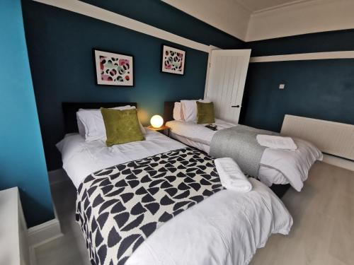2 camas en una habitación con paredes azules en Large 5 Bed House, 9 Beds + Parking + 3 bathrooms en Wirral