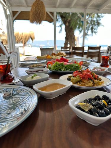 una mesa de madera con platos de comida. en Apelles Butik Otel, en Seferihisar