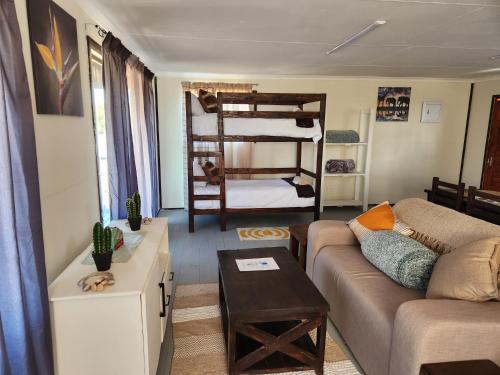 a living room with a couch and a bunk bed at Cozy Cabin Country Cottage in Skeerpoort
