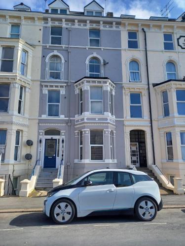 a white car parked in front of a building at 2 Beach House in Bridlington
