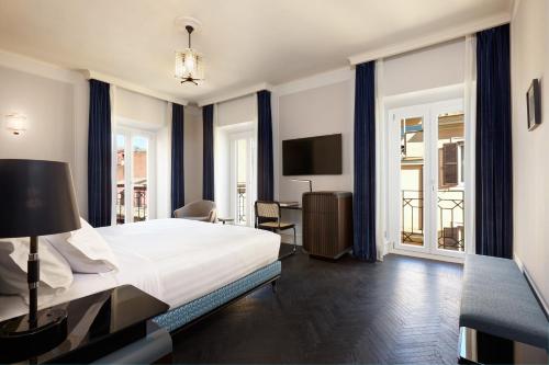 um quarto com uma cama e uma secretária com uma televisão em TB Place Roma em Roma