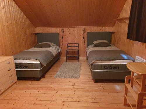 een kamer met 2 bedden en een stoel. bij Chalet Bonne Humeur in Houffalize