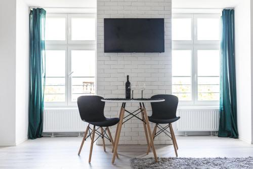 トルンにあるPrzytulny Apartament przy Starym Mieścieのテーブルと椅子2脚のあるダイニングルーム