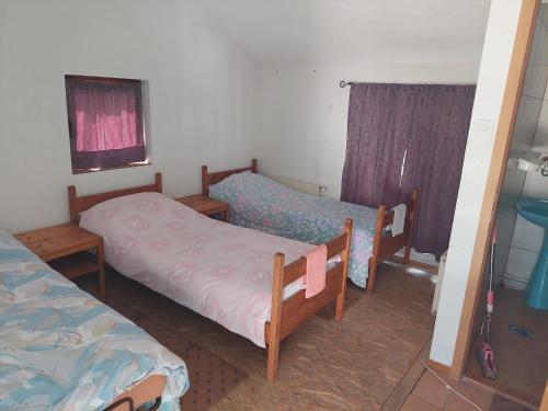 um pequeno quarto com 2 camas e uma janela em 33 Lipe em Travnik